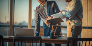 Car accident lawyers reviewing a client's injury claim documents at a desk.